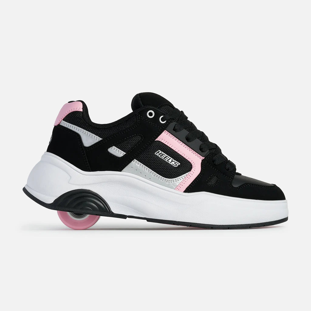 A black and white sneaker with pink accents and a pink wheel, shown from the side on a light gray background. The brand name 'NEKTS' is visible on the side of the shoe.