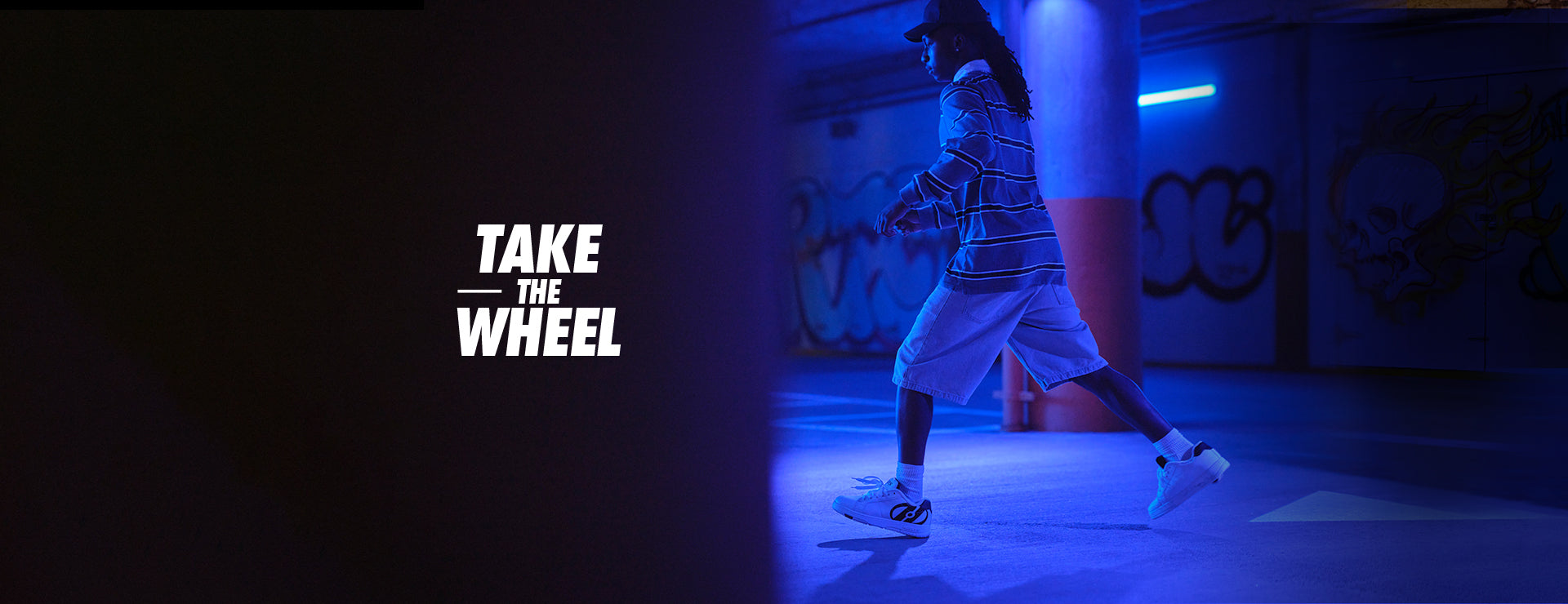 Person dancing in a dark room with blue lighting, featuring the text 'Take the Wheel'.