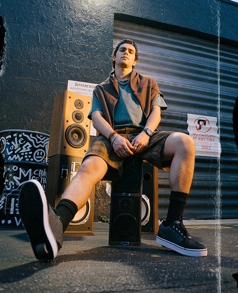 Person sitting on a speaker system with a dark background