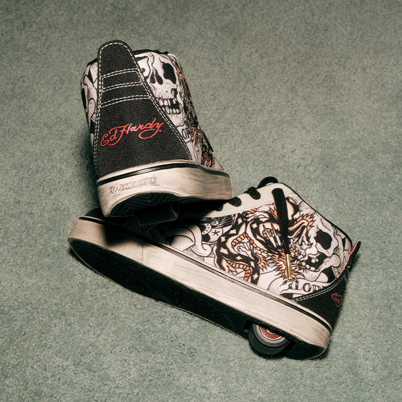 Pair of sneakers with tattoo-style designs on a gray background