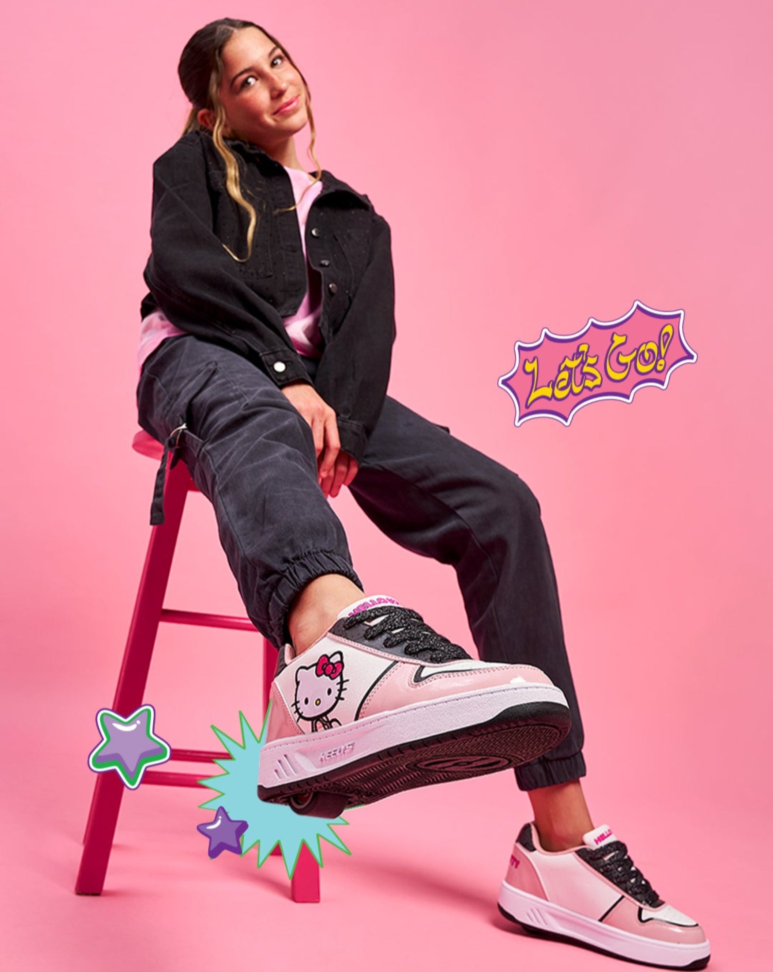 Person wearing Heelys x Hello Kitty shoes on a pink background with colorful graphics and text.