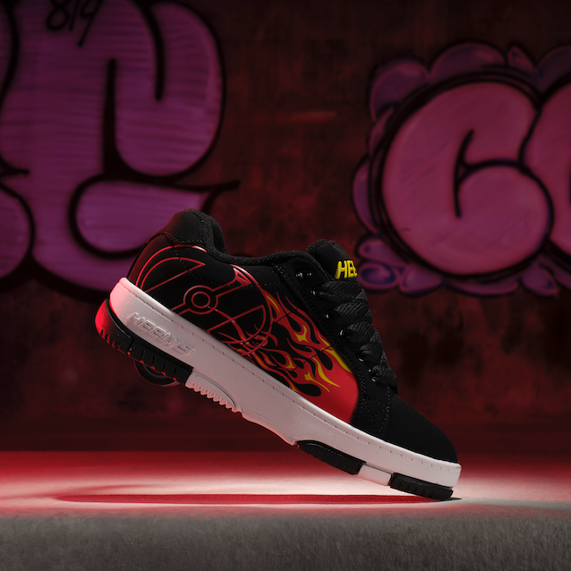 Black sneaker with red accents on a dark background with graffiti-style text