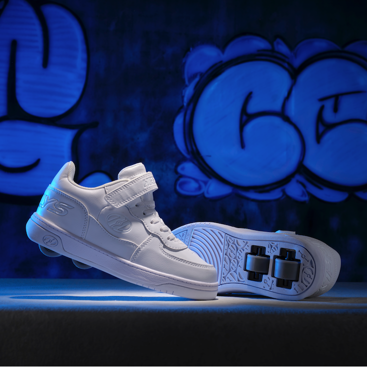 White sneakers with black accents on a dark background with blue lighting