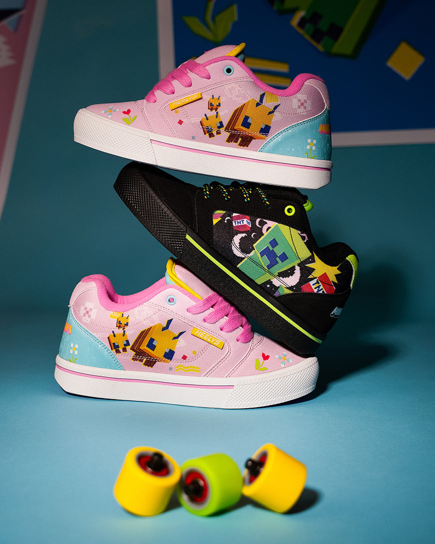 Three colorful Minecraft-themed sneakers are arranged in a stacked display on a blue studio background, with three matching yellow, green, and yellow wheels placed in front. The shoes feature pixelated character graphics and branding.