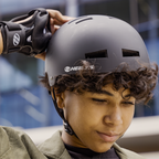 Child wearing a helmet and knee pads in an urban setting